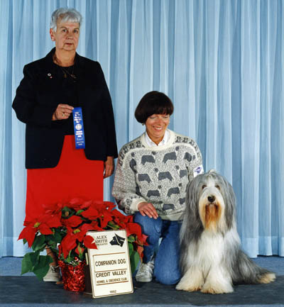 Smokey also worked at obedience and earned his Companion Dog title. He is shown here with his mommy and the judge after completing the requirement for his title.